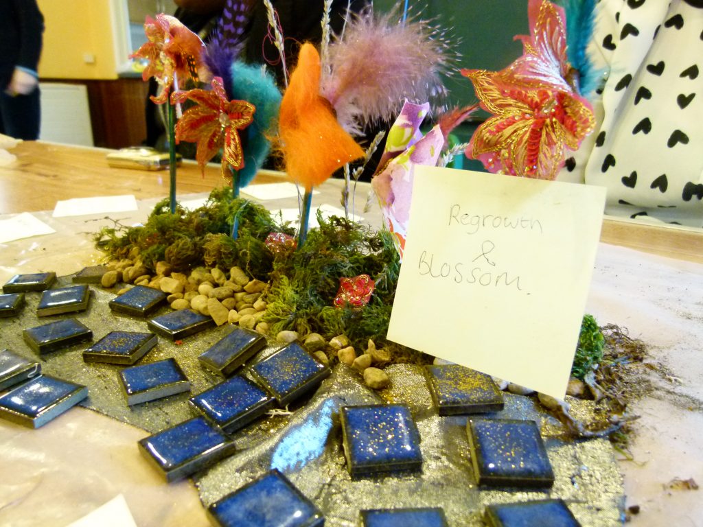 3D model made with blue tiles, pebbles, moss, twigs, cloth and feathers