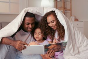 Family reading under covers