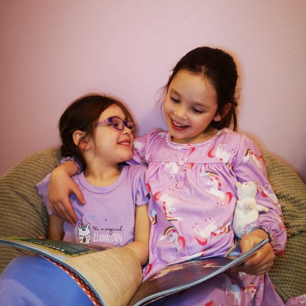 Two girls reading together
