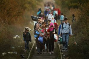 SUBOTICA, SERBIA - SEPTEMBER 09: Migrants make their way through Serbia, near the town of Subotica, towards a break in the steel and razor fence erected on the border by the Hungarian government on September 9, 2015 in Subotica, Serbia. Thousands of migrants have funnelled their way across country to the small gap in the steel fence unopposed by the authorities. Since the beginning of 2015 the number of migrants using the so-called 'Balkans route' has exploded with migrants arriving in Greece from Turkey and then travelling on through Macedonia and Serbia before entering the EU via Hungary. The number of people leaving their homes in war torn countries such as Syria, marks the largest migration of people since World War II. (Photo by Christopher Furlong/Getty Images) *** BESTPIX ***