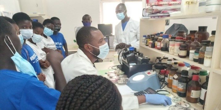 Interacting with the youth from Gbegbeyise, observing bacteria colonies in CSIR-WRI Microbiology Laboratory.