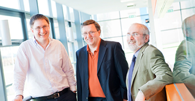 Image shows Professors Eckley, Tawn, and Glazebrook (left to right) standing in the PSC Building at Lancaster University.