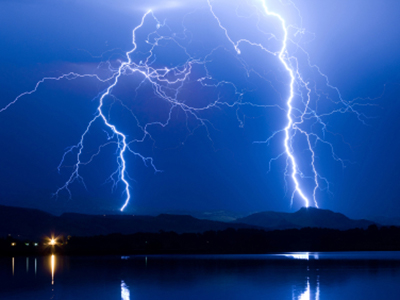 Stock image of lightning at night over a lake.