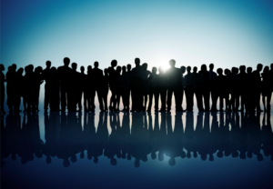 A group of human beings in shadow form facing the horizon.